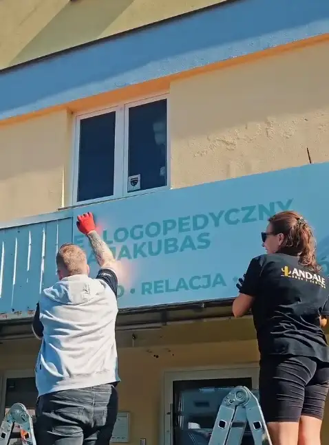 Andale w trakcie montażu szyldu reklamowego